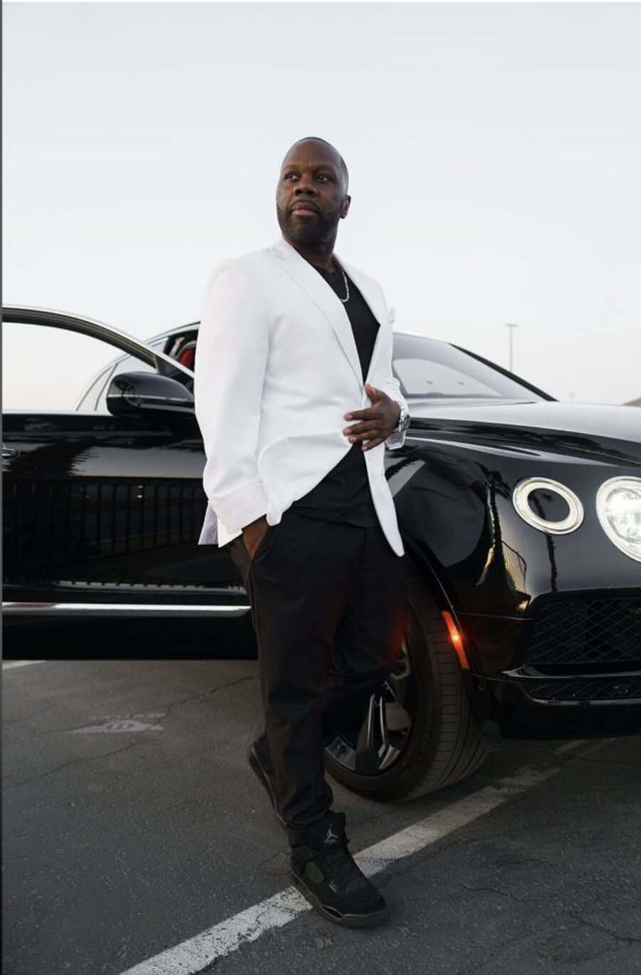 Antoine Sallis standing beside a black luxury car